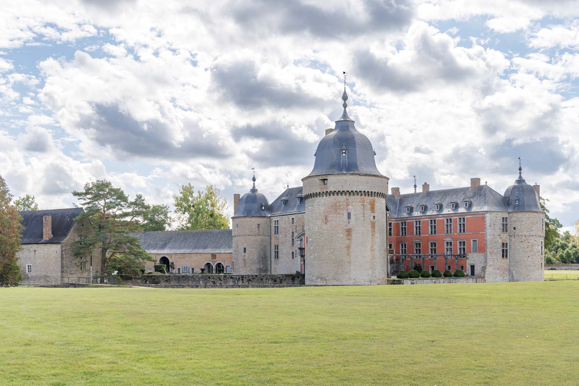Château de Lavaux Sainte-Anne avec tours rondes et douves, dans un cadre verdoyant