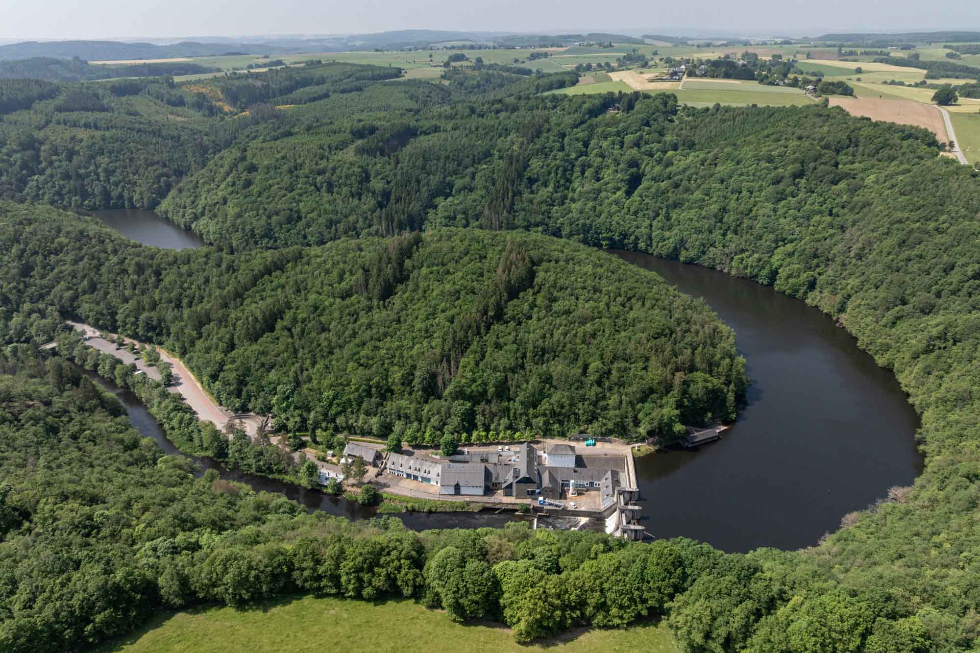 Luchtbeeld van de stuwdam van Nisramont omringd door bos