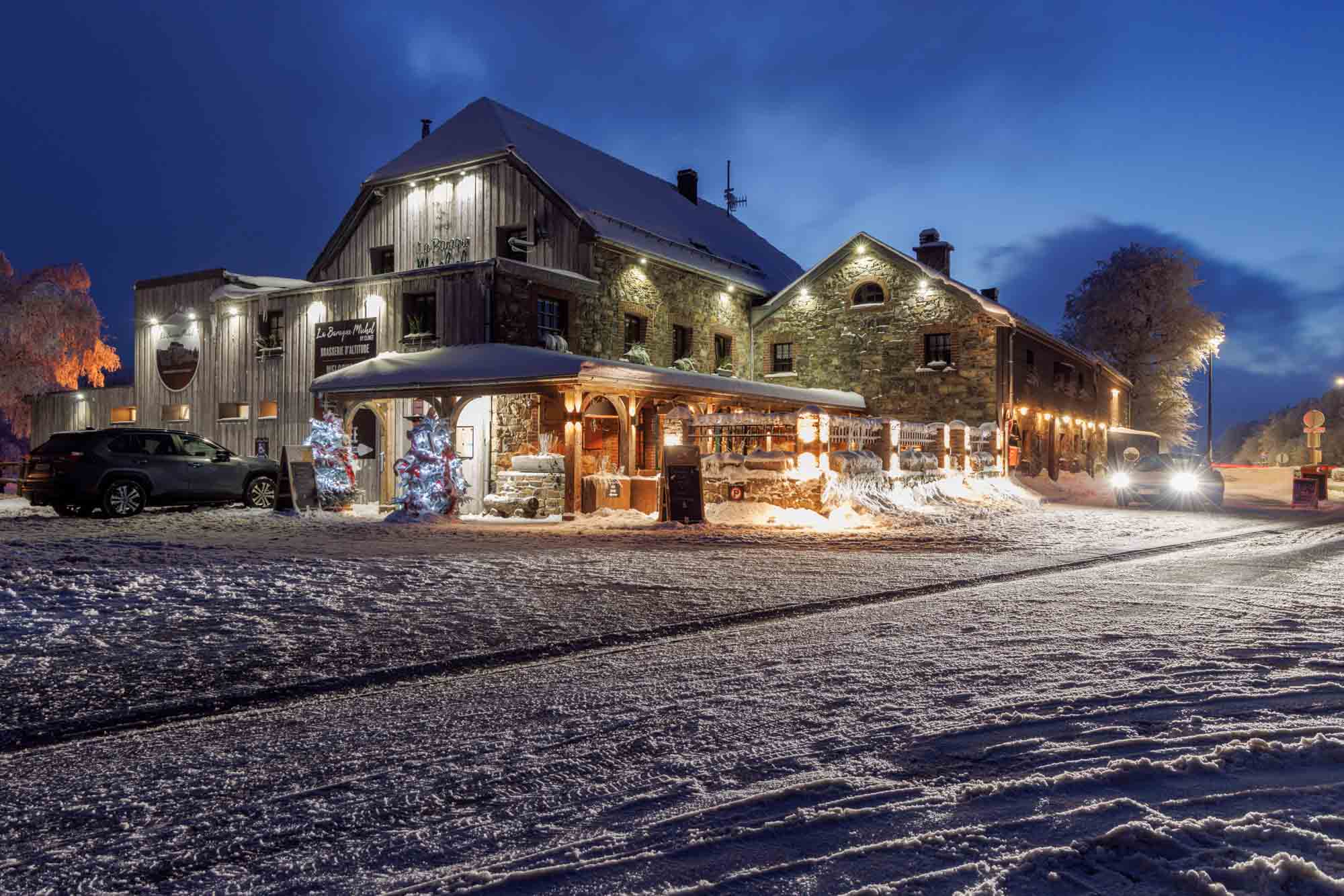 Baraque Michel de nuit sous la neige, bâtiment éclairé dans les Hautes Fagnes