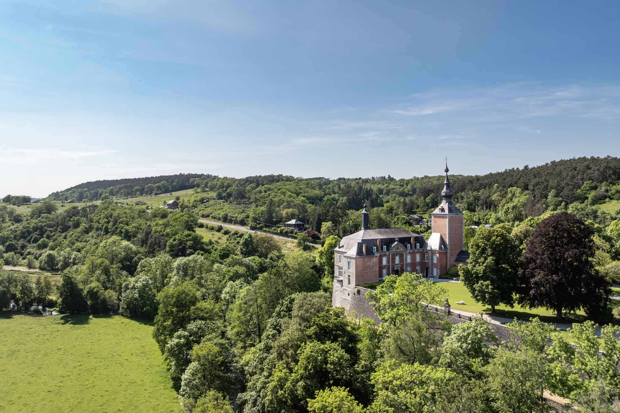 Vierves-sur-Viroin met kasteel en stenen huizen boven een groene vallei in het voorjaar.